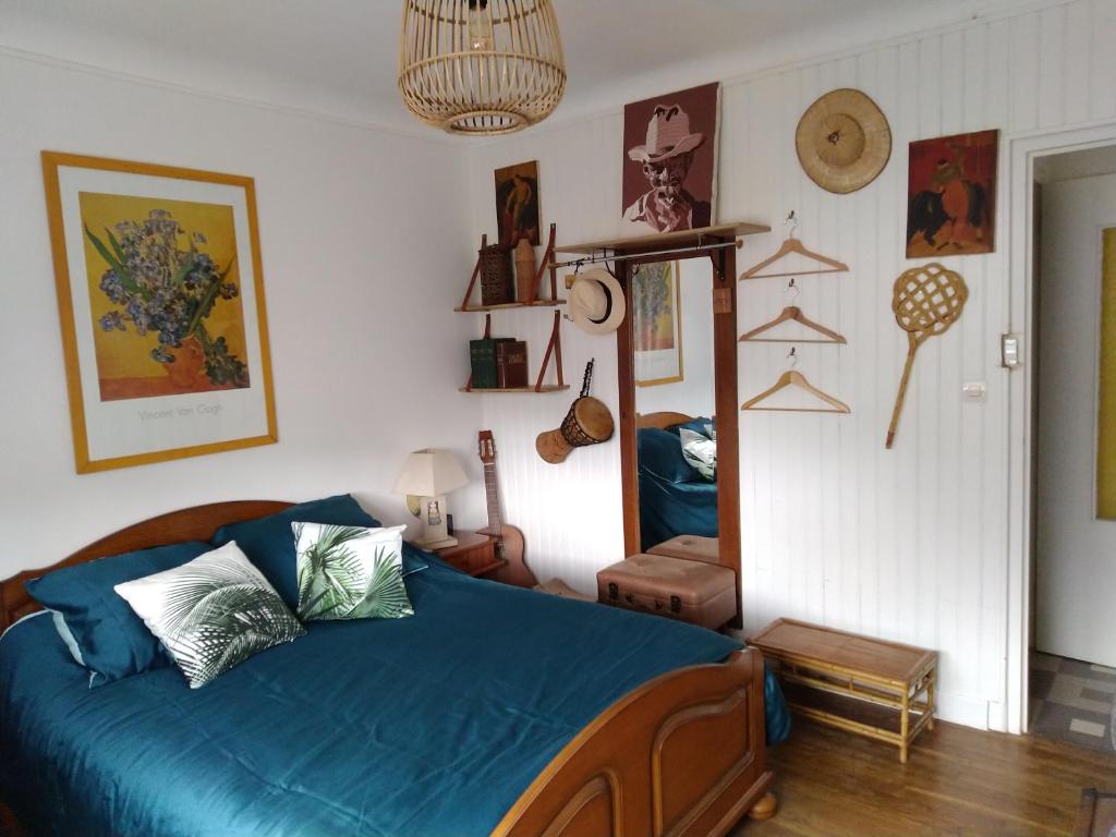 Un dormitorio con una cama con sábanas azules y un espejo. en Chambre César B&B- au 1er - Villa Chaumonty, en Périgueux