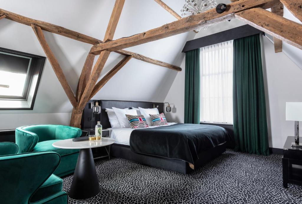 a bedroom with a bed and a table and chairs at Poorter Boutique Hotel Brielle in Brielle