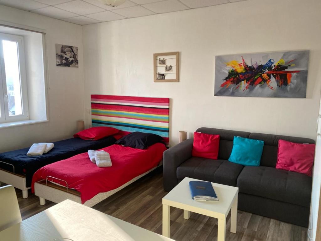 a living room with a couch and a bed at charmand studio dans l ancien hotel le continental in Vittel