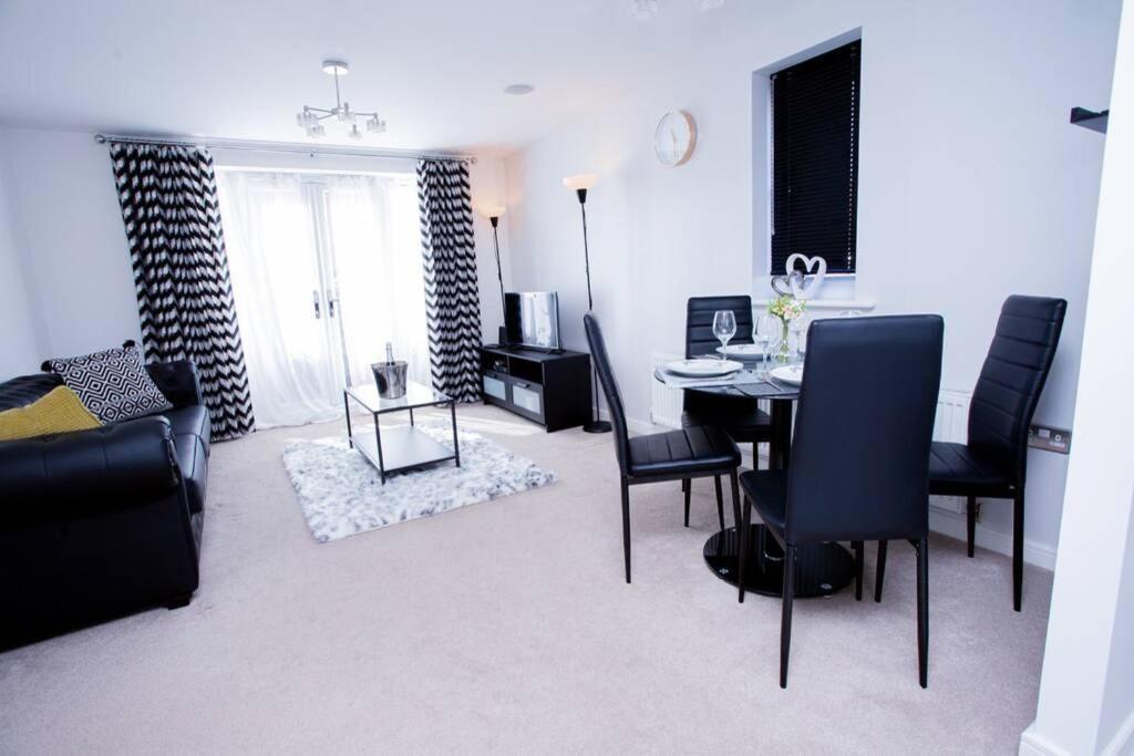 a living room with a dining room table and chairs at Mills Apartment - Two bedroom en-suite apartment in Northampton