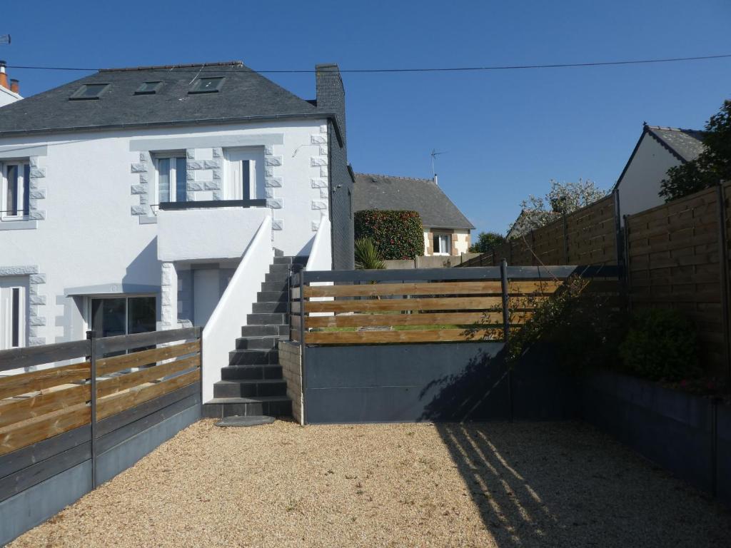 a house with a fence and stairs in front of it at Le gîte du forgeron in Trélévern