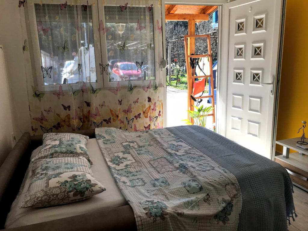 uma cama num quarto com uma janela e uma porta em Studio em Tivat