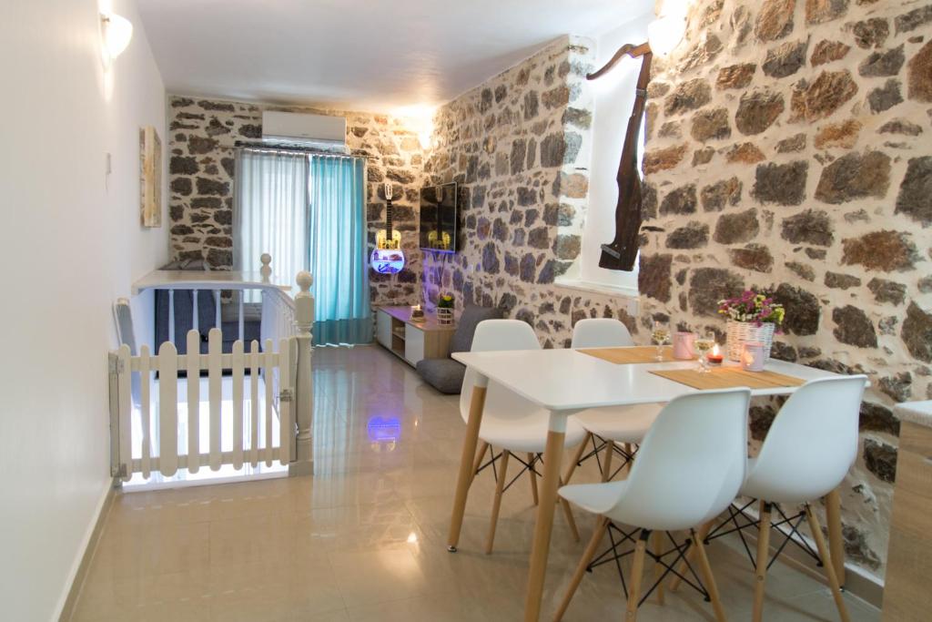 a dining room with stone walls and a table and chairs at Sokaki House in Hydra