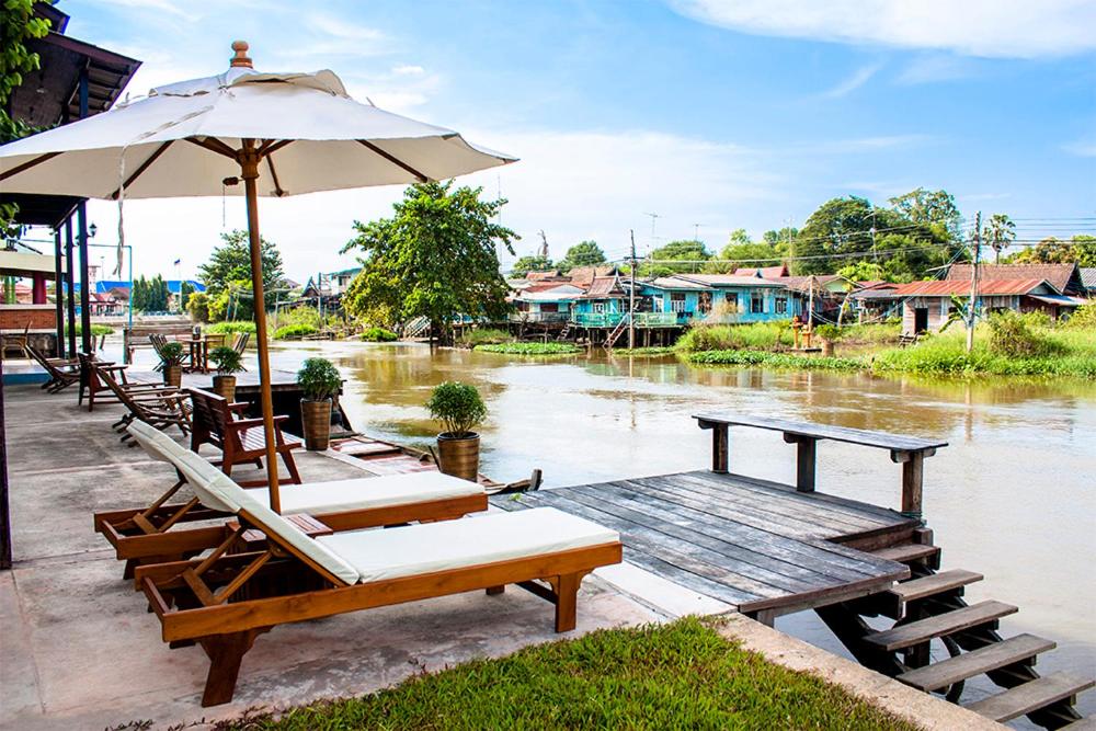 The Bank River House Ayutthaya في Ban Yai (1): مجموعة طاولات وكراسي مع مظلة وماء