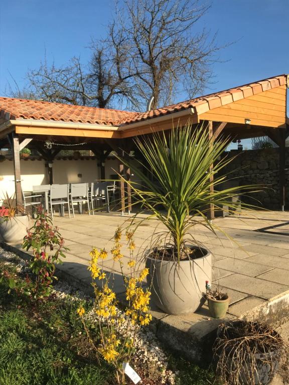 a patio with a wooden pergola and some plants at Maison Tranquille in Champniers-et-Reilhac