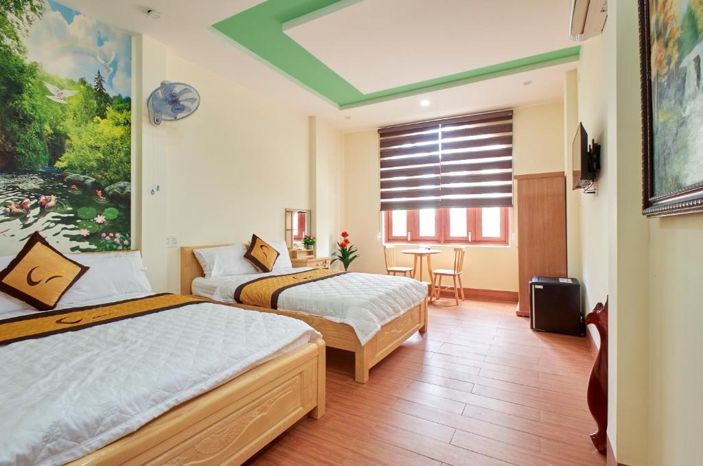 a hotel room with two beds and a window at THANH TÙNG HOTEL in Quy Nhon