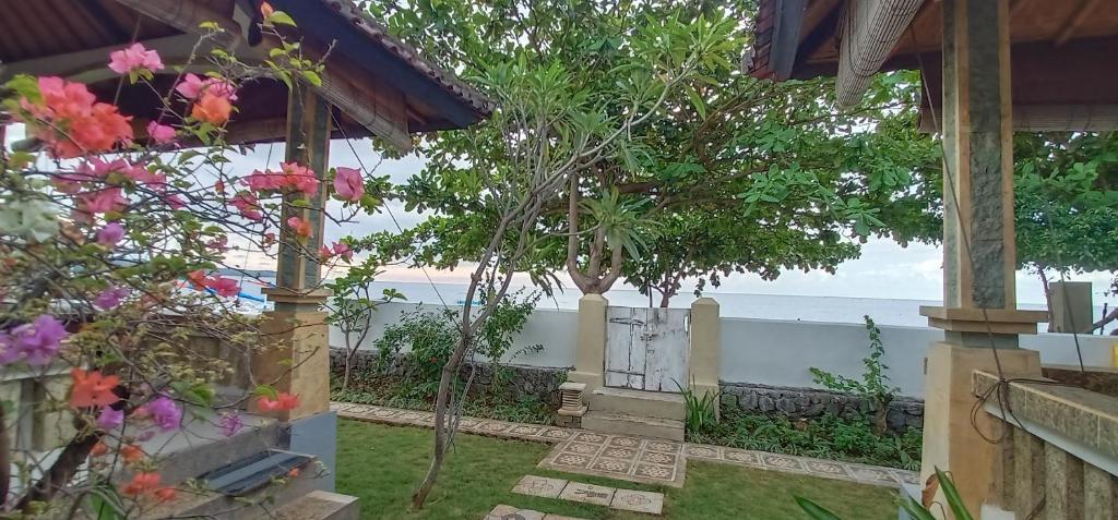 a garden with a view of the ocean at Solaluna Beach Homestay in Amed
