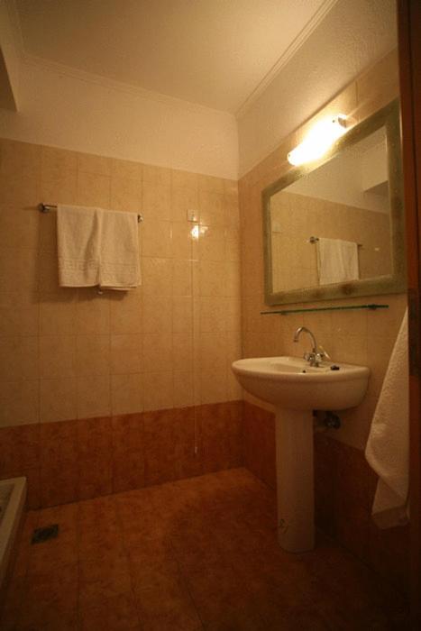 a bathroom with a sink and a mirror and towels at Akti Damnoni in Damnoni