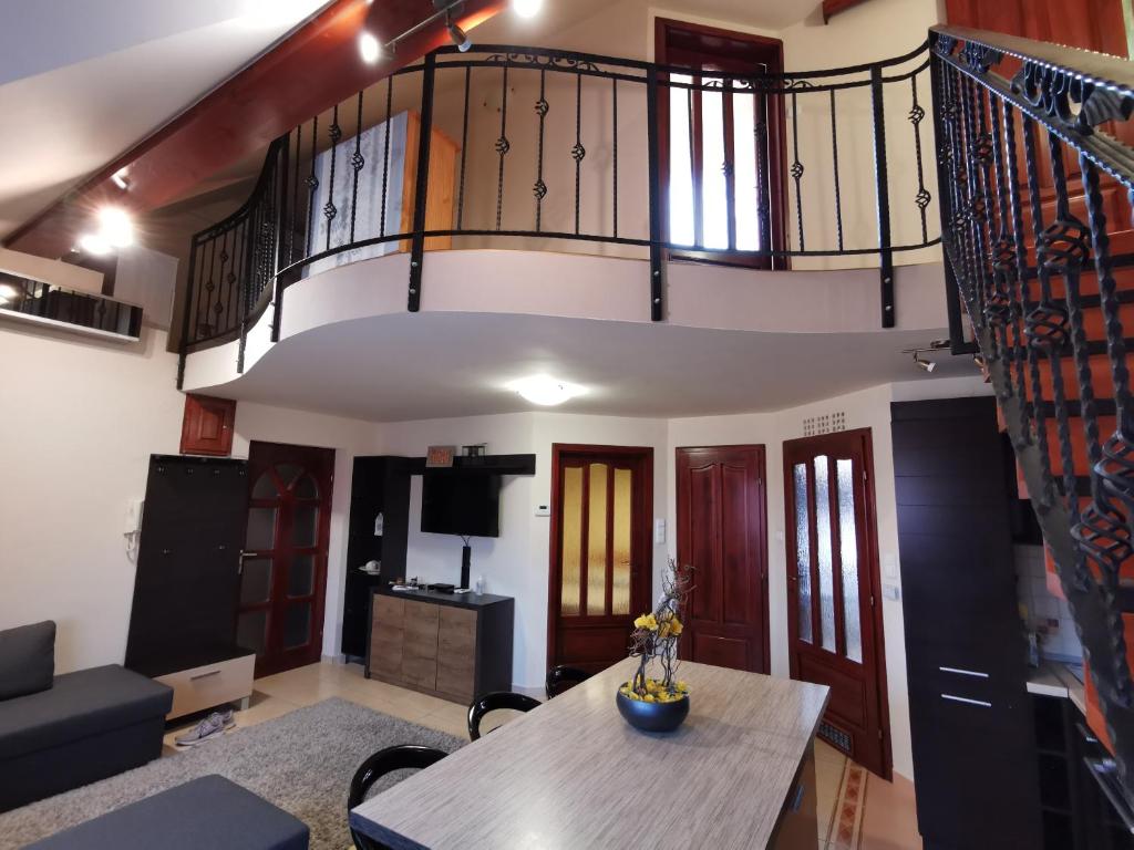 a living room with a staircase and a table at Galery Apartman in Gyula