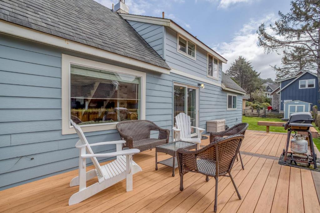 a deck with chairs and a table on a house at By The Sea in Lincoln City