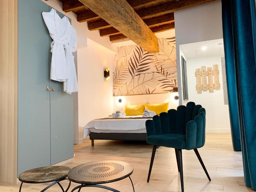 a bedroom with a bed and a green chair at Luxe et Calme en Hyper Centre - La Cour des Bois in Lyon