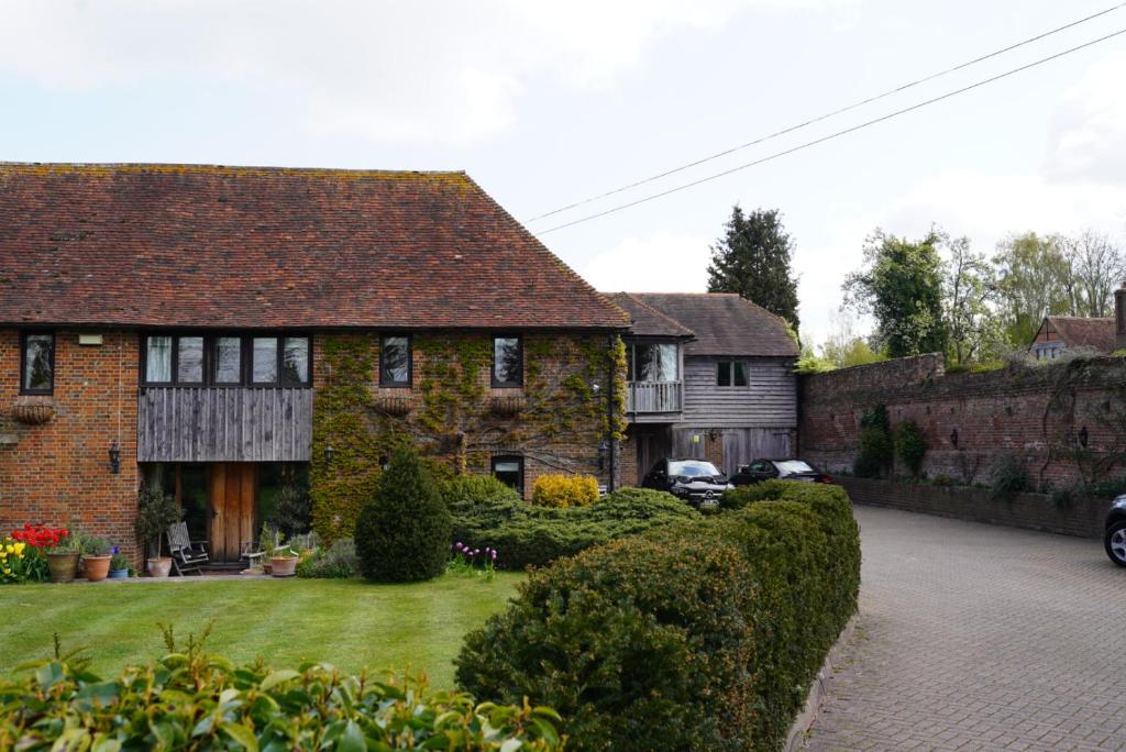 une vieille maison en briques avec une cour devant elle dans l'établissement Finchden Barn, à Tenterden