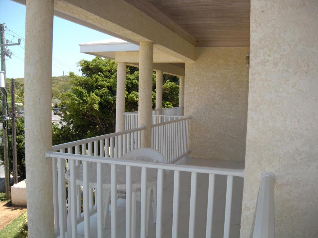 a porch of a house with a white railing at Sapphire Garden Townhouses in Georgetown