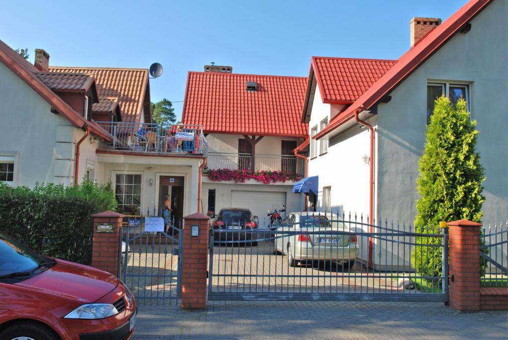 una macchina rossa parcheggiata di fronte a una casa di Dom Pod Jeleniem a Łeba