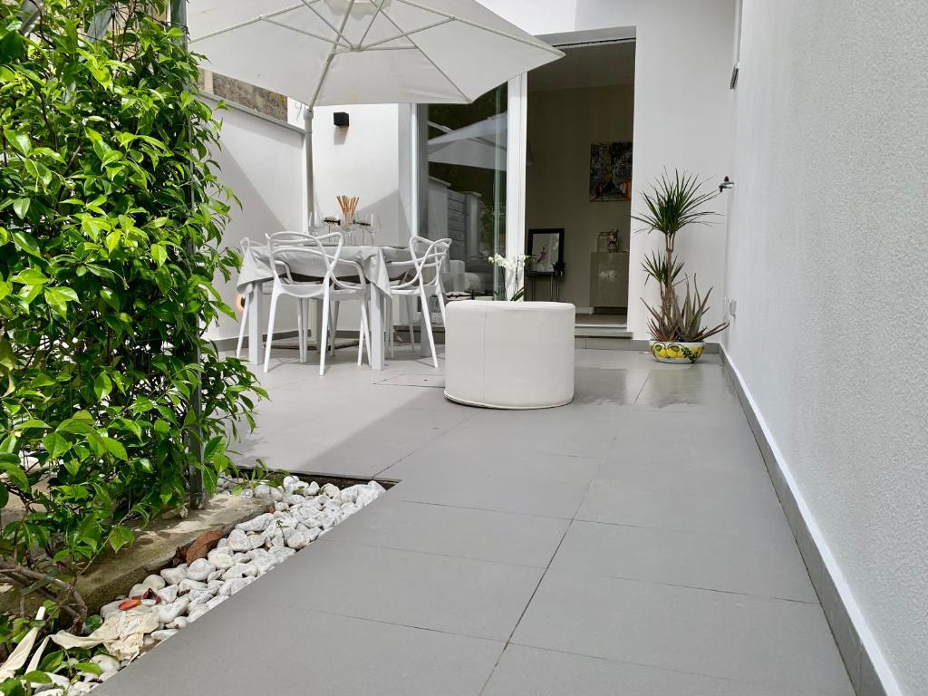 a patio with a table and an umbrella at Villa Luminosa in Torre del Lago Puccini