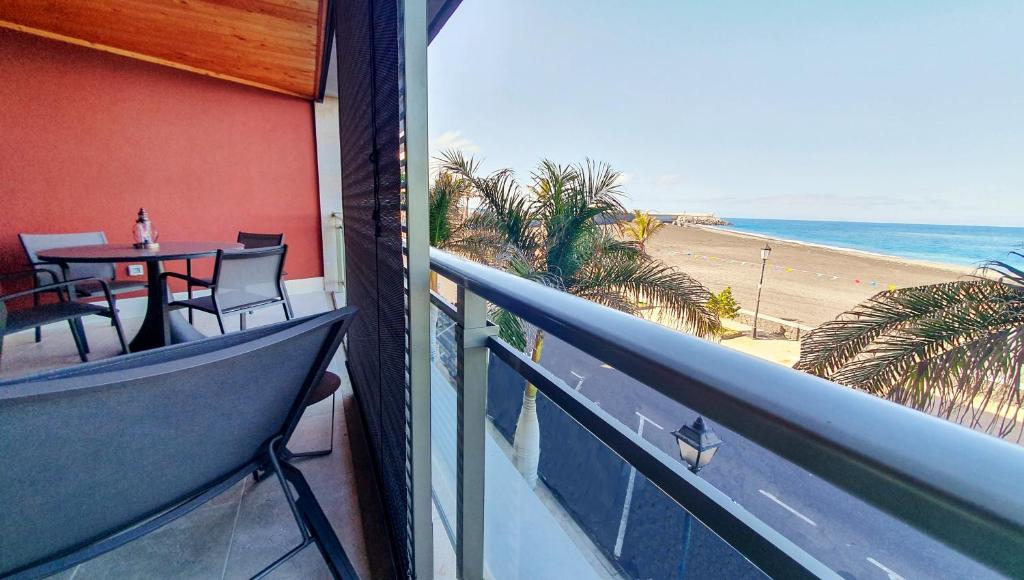 einen Balkon mit einem Tisch und Strandblick in der Unterkunft El Ancla in Tazacorte