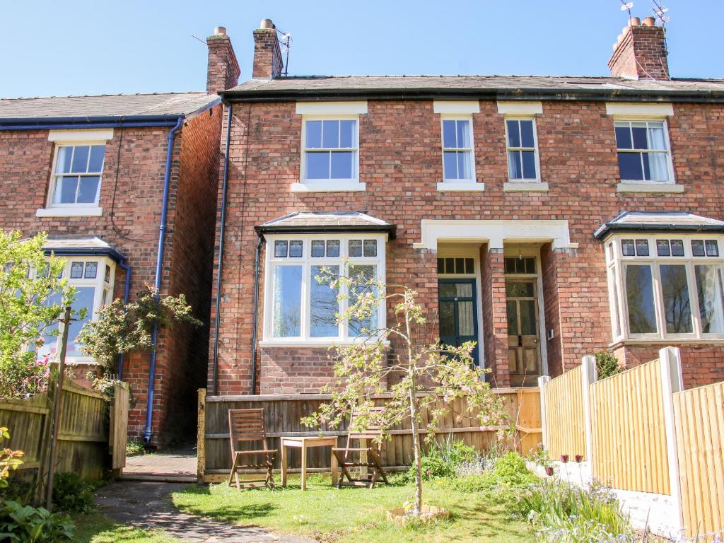 a brick house with a table and chairs in the yard at Willow View in Shrewsbury