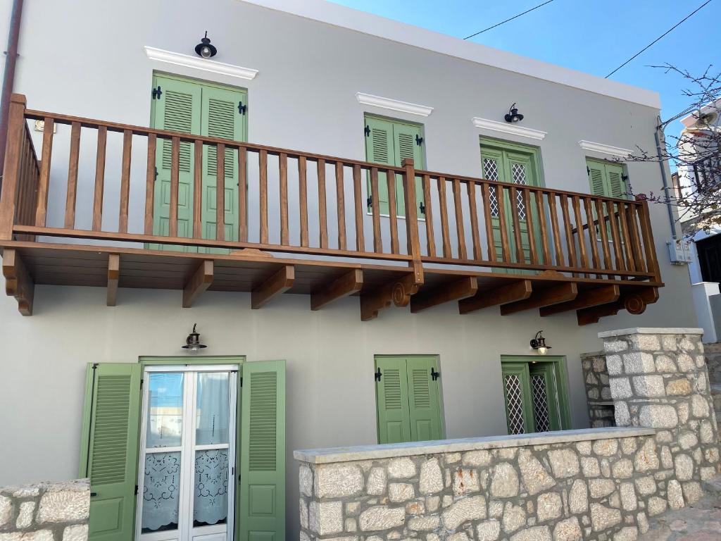 una casa con escalera y persianas verdes en LUCA'S HOUSES, en Halki