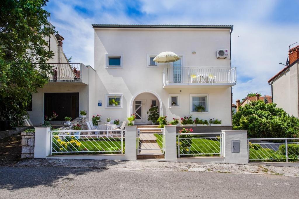Biały dom z białym płotem przed nim w obiekcie Apartment in Rovinj with balcony, air conditioning, Wi-Fi (230-1) w Rovinj