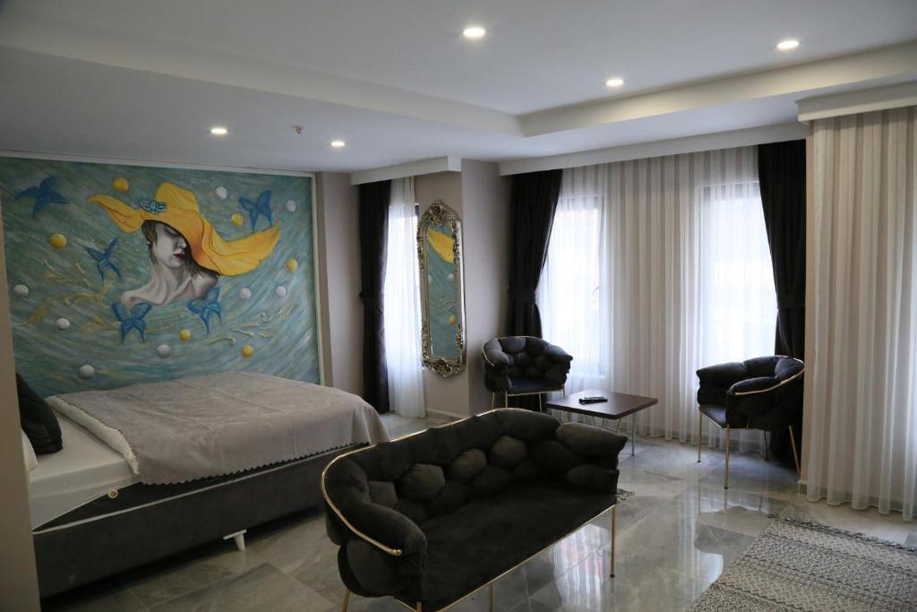 ein Schlafzimmer mit einem Bett und einem Sofa und einem Gemälde in der Unterkunft ATİK HOTEL in Istanbul