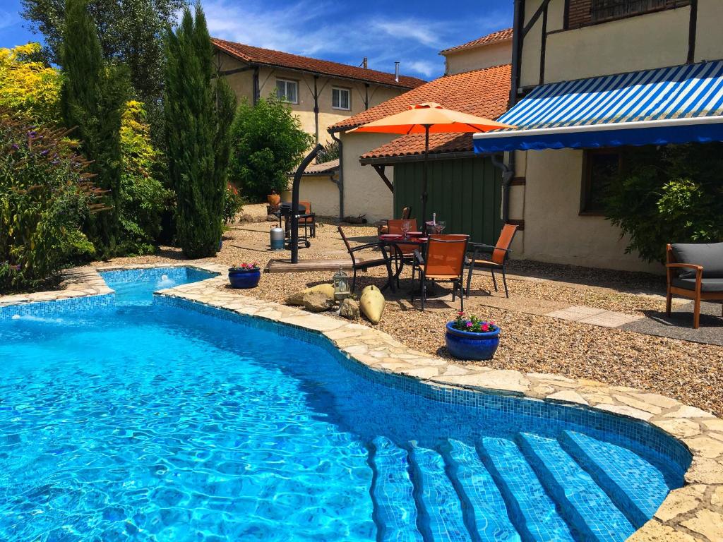 una piscina con mesa y sillas junto a una casa en Gite Les Pignons en Roquebrune