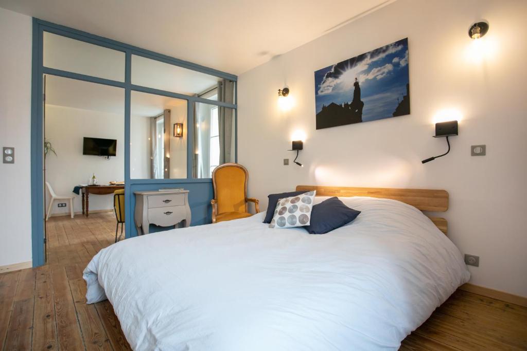 a bedroom with a large white bed and a desk at Péribleu in Périgueux