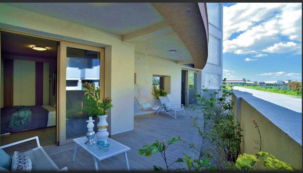 a balcony of a house with a bed and a table at Mediterraneo Apartments ARGENTO in Marzamemi