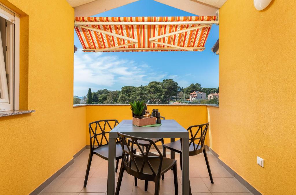 jadalnia ze stołem i krzesłami oraz oknem w obiekcie Apartment Vito with sea view w Fažanie
