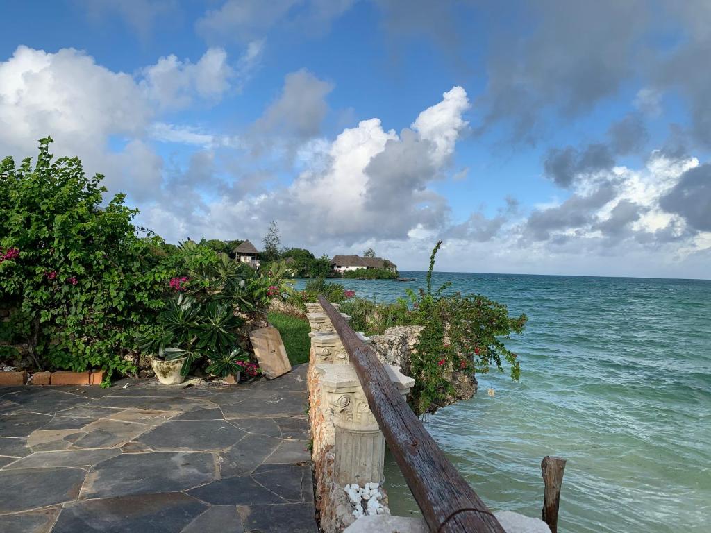 una valla de madera con vistas al océano en Malcom Residence en Pongwe