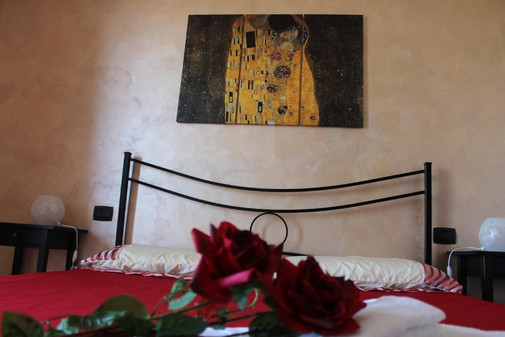 B&B Colle Sul Mare في تيرمولي: غرفة نوم بسرير مع شراشف حمراء ولوحة