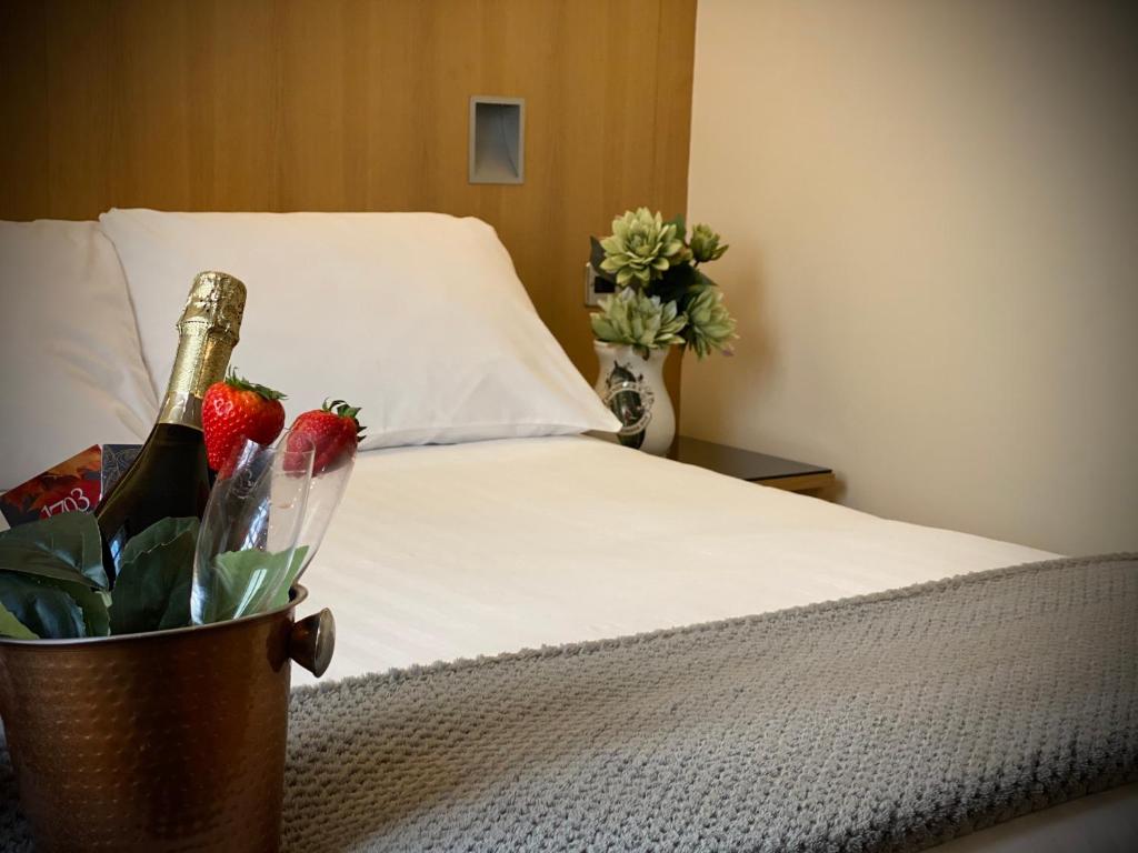 a bed with a vase of flowers on top of it at Rooms at 1703 in Dunfermline