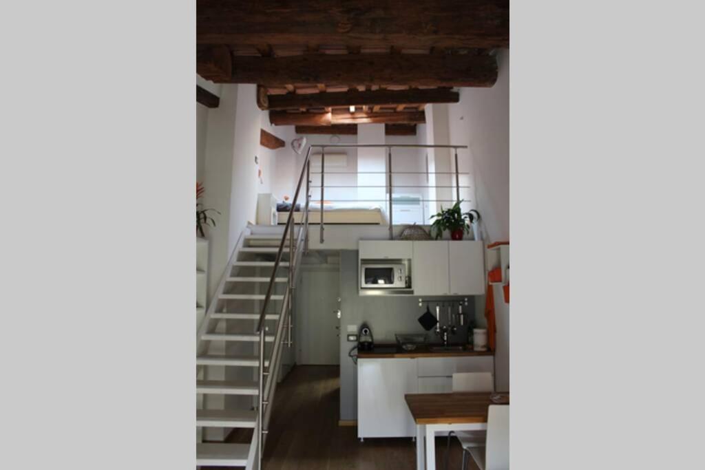 a room with a staircase and a kitchen with a microwave at Fiordiloto57 in Mantova