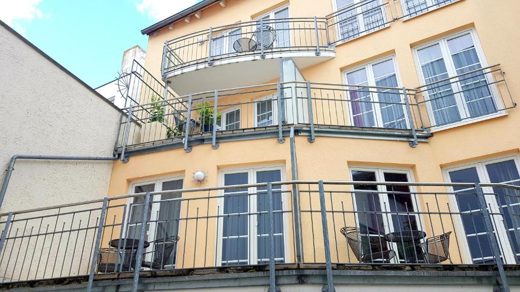 un edificio amarillo con balcones y sillas. en Villa Viktoria 1 en Ingolstadt