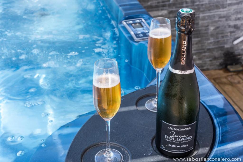 two glasses of champagne on a table next to a swimming pool at La case Maui in La Saline les Bains