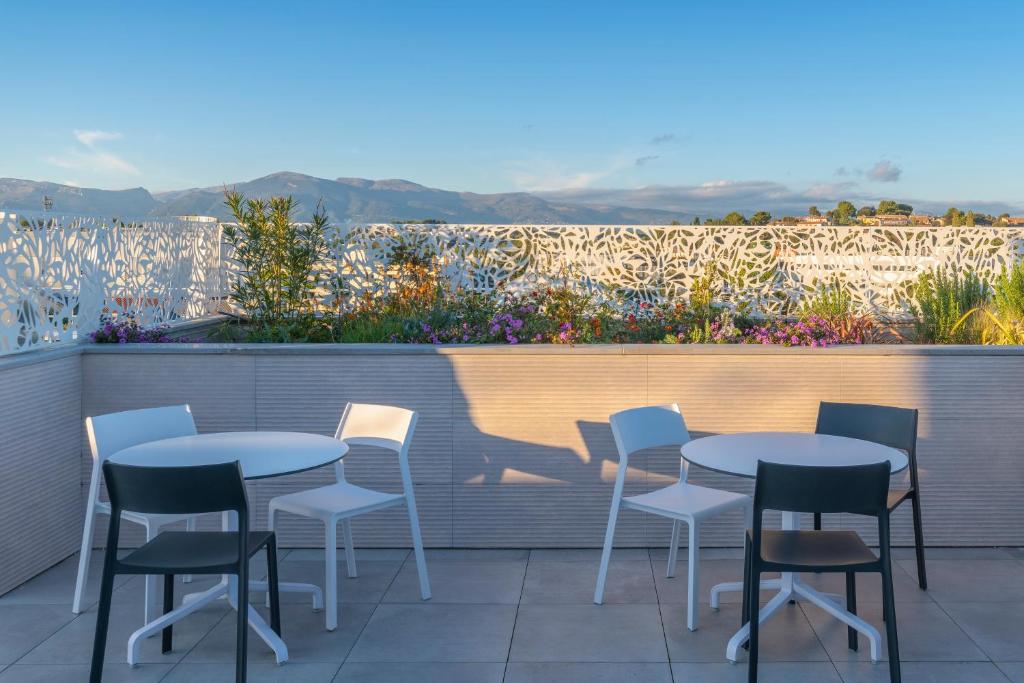 a group of tables and chairs on a patio at Lagrange Apart&#39;Hôtel Antibes Olympie in Antibes