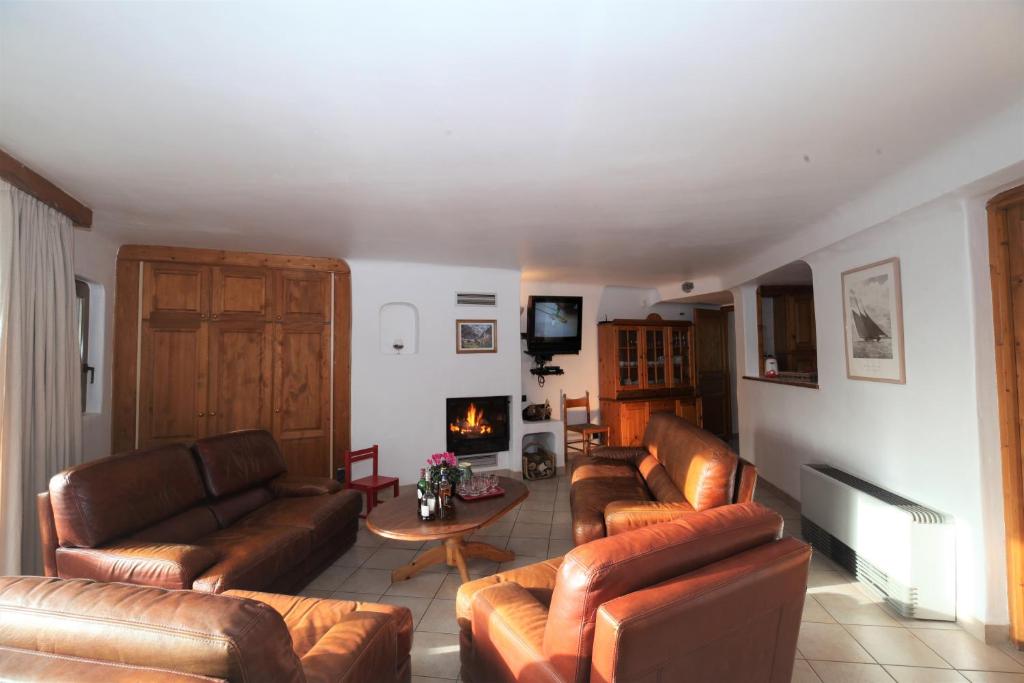 a living room with leather couches and a fireplace at Chalet Bouquetin- Chamois 8 to 11 people in Champagny-en-Vanoise