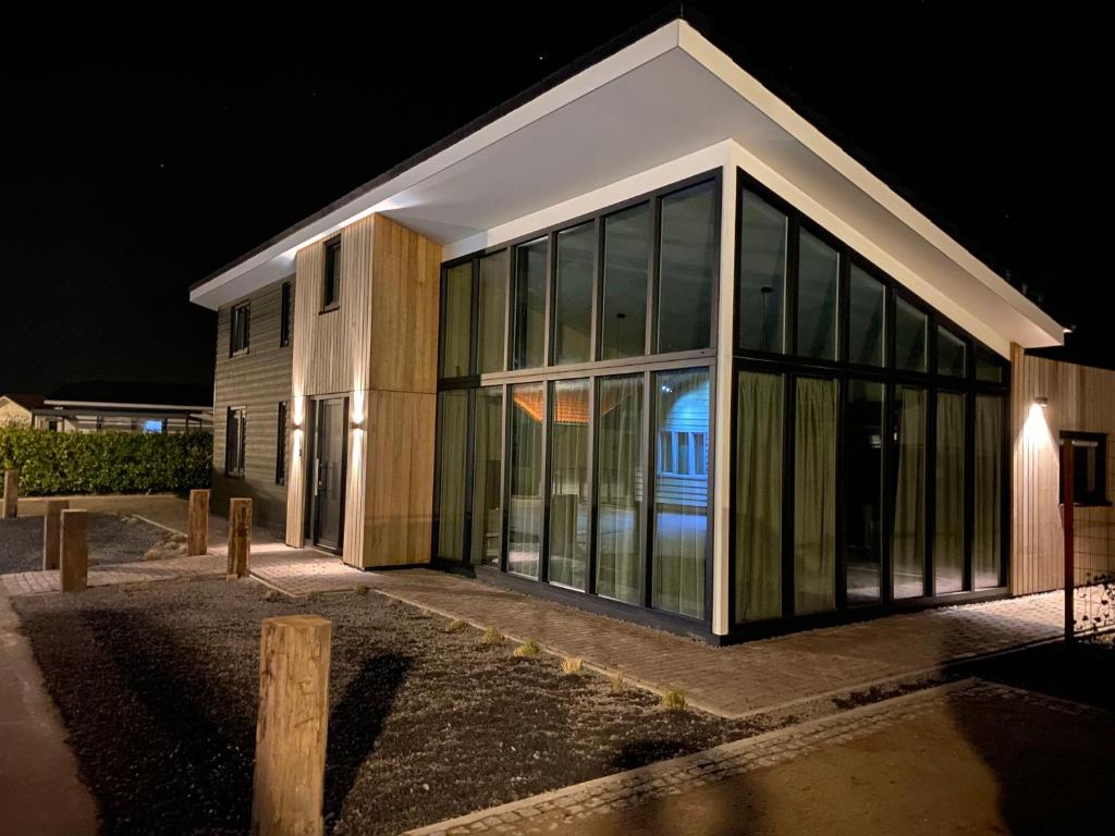 um edifício com grandes janelas de vidro à noite em Maison Jolie em Sint-Annaland