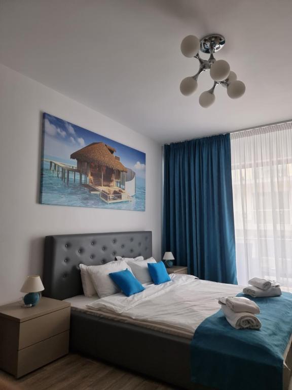 een slaapkamer met een groot bed met blauwe kussens bij DeSilva - Summer Holidays in Mamaia