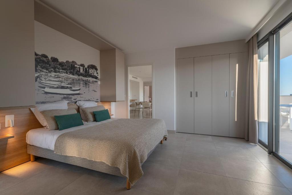 a bedroom with a bed and a view of the ocean at Lagrange Apart&#39;Hôtel Antibes Olympie in Antibes