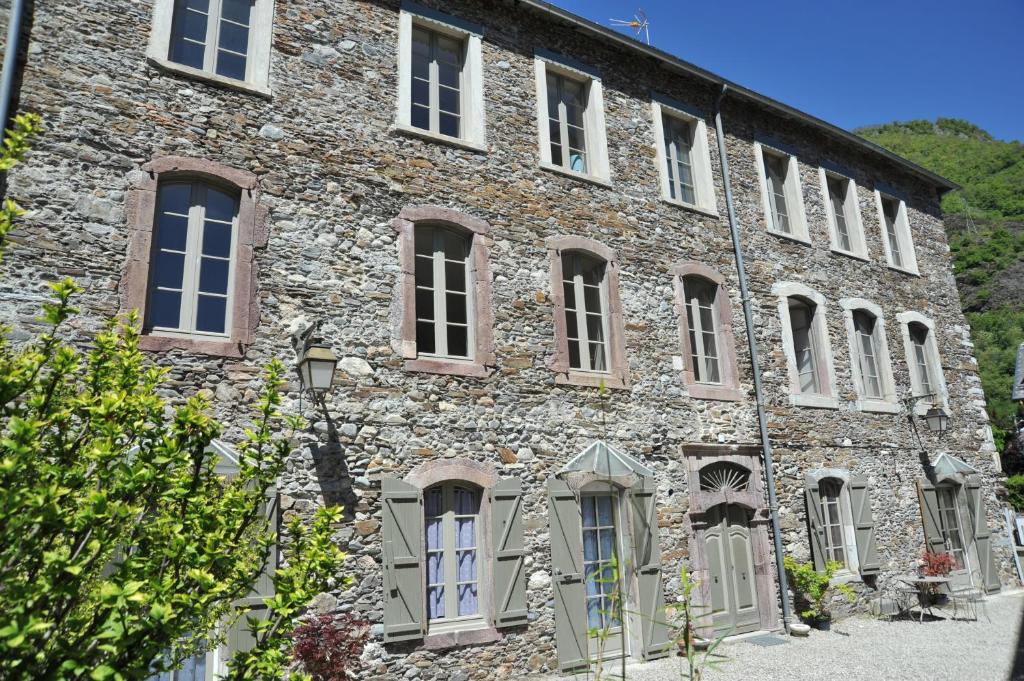 Ein altes Steingebäude mit vielen Fenstern in der Unterkunft Résidence BAVARA in Luchon