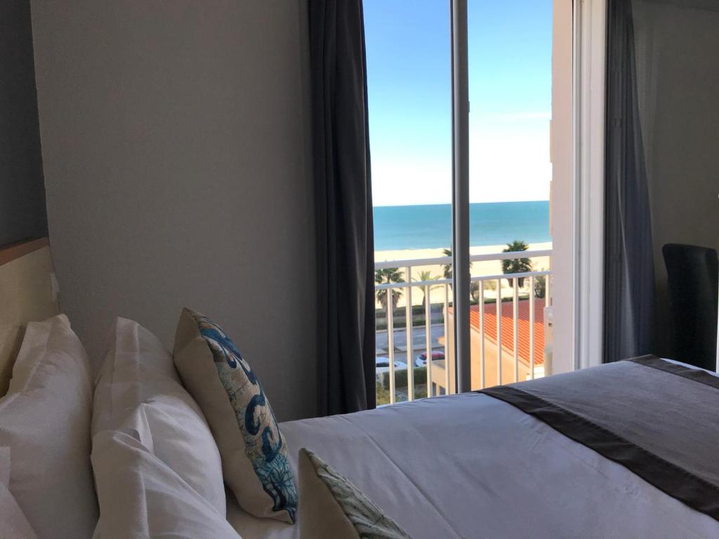 una camera con letto e vista sull'oceano di Le Regina Hôtel et restaurant Canet-plage a Canet-en-Roussillon