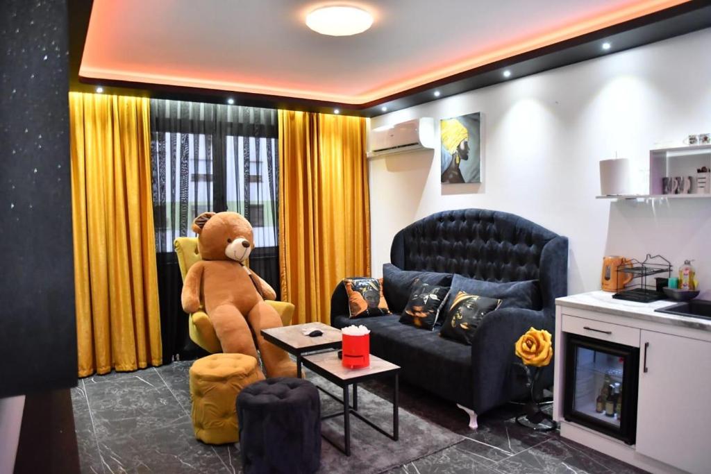 ein Wohnzimmer mit einem Teddybär auf einem Stuhl in der Unterkunft Apartman S&V 3 Istocno Sarajevo Lukavica sa Jacuzzi Lux Spa Hilandarska Centar in Lukavica