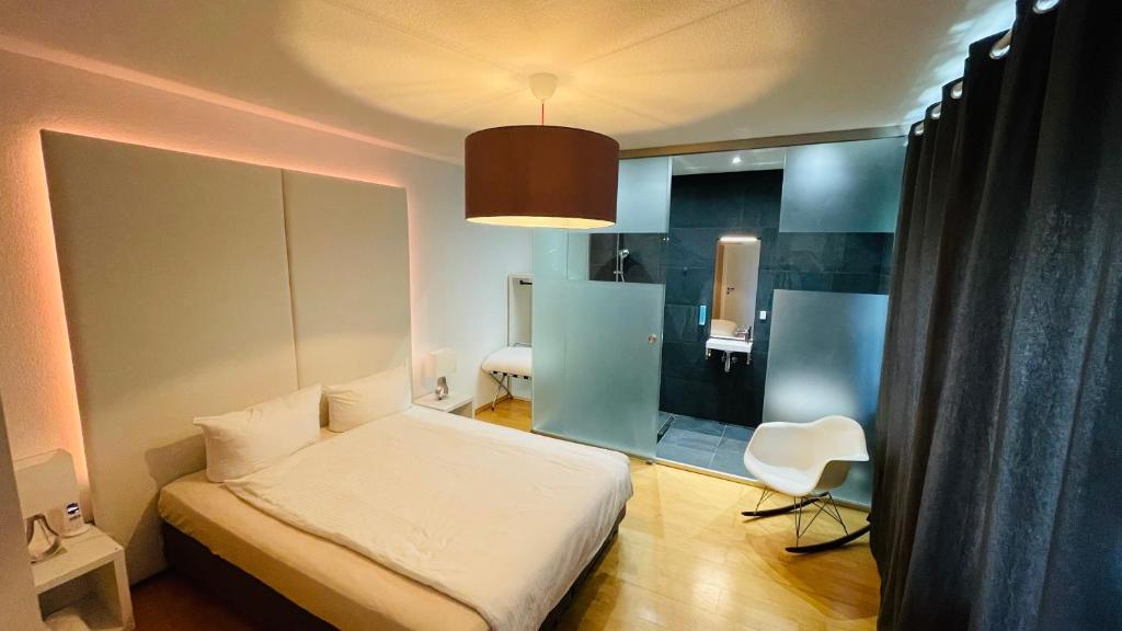 Nordkirchenにあるsmart&beautiful Guesthouseのベッドと椅子付きの小さな部屋です。