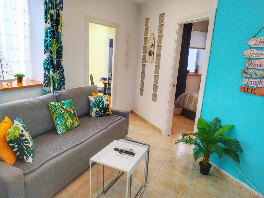 uma sala de estar com um sofá e uma mesa em Apartamento junto a Calle Larios em Málaga
