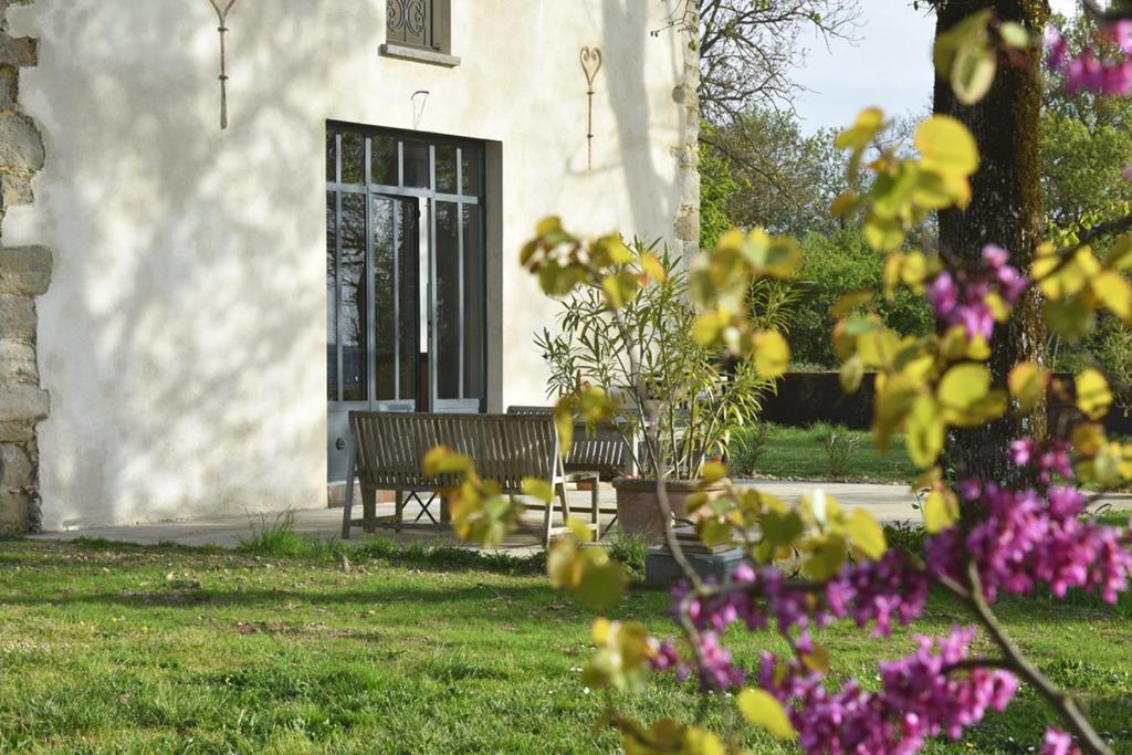 un banc devant une maison fleurie dans l'établissement la serre d Embarthe, à La Pomarède