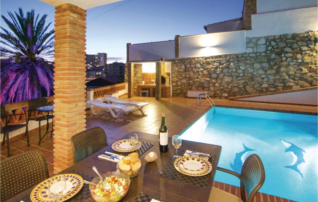 uma piscina com uma mesa e uma sala de jantar em Beautiful Apartment In Fuengirola, Malaga With 2 Bedrooms, Wifi And Outdoor Swimming Pool em Fuengirola