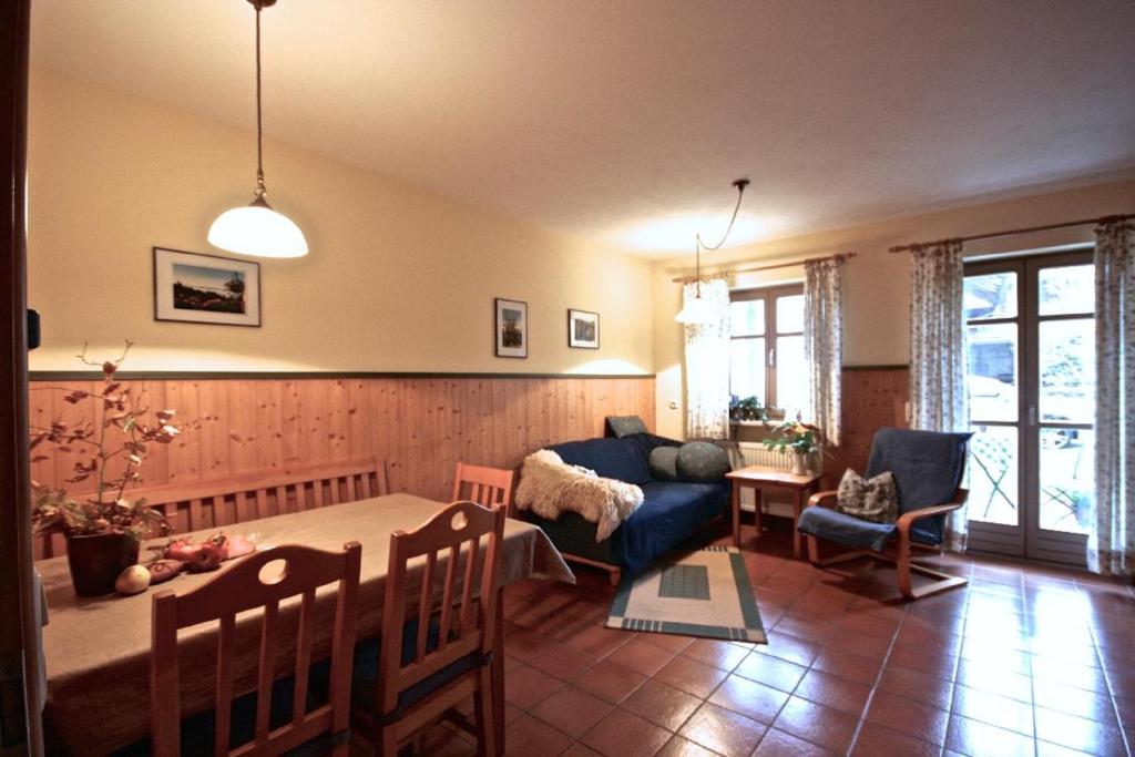 ein Wohnzimmer mit einem Tisch und einem blauen Sofa in der Unterkunft Landhof Fischer in Geiersthal