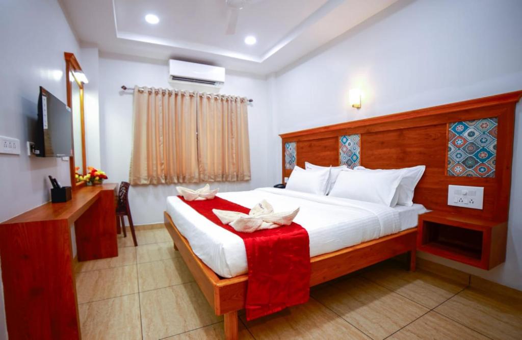 - une chambre avec un lit, un bureau et une télévision dans l'établissement ABI`S RESIDENCY, à Thanjavur