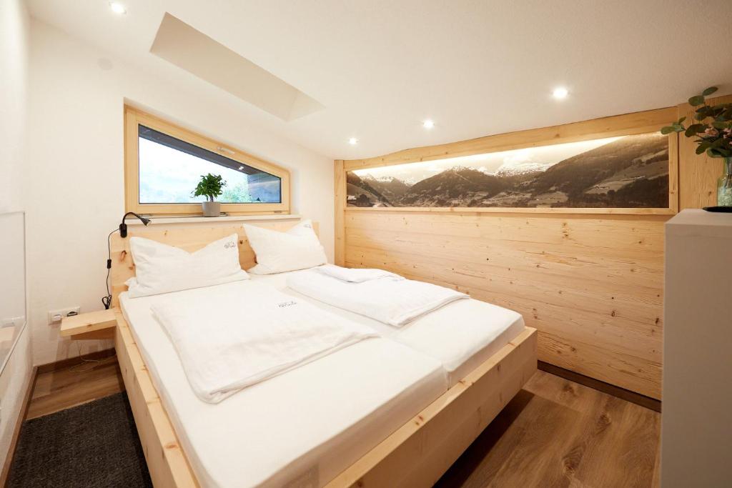 een slaapkamer met een groot wit bed in een kamer bij Mäxle Apartments in Bad Hofgastein