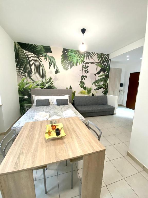a dining room with a table and a couch at LE PALME Loft Apartment in Fossano